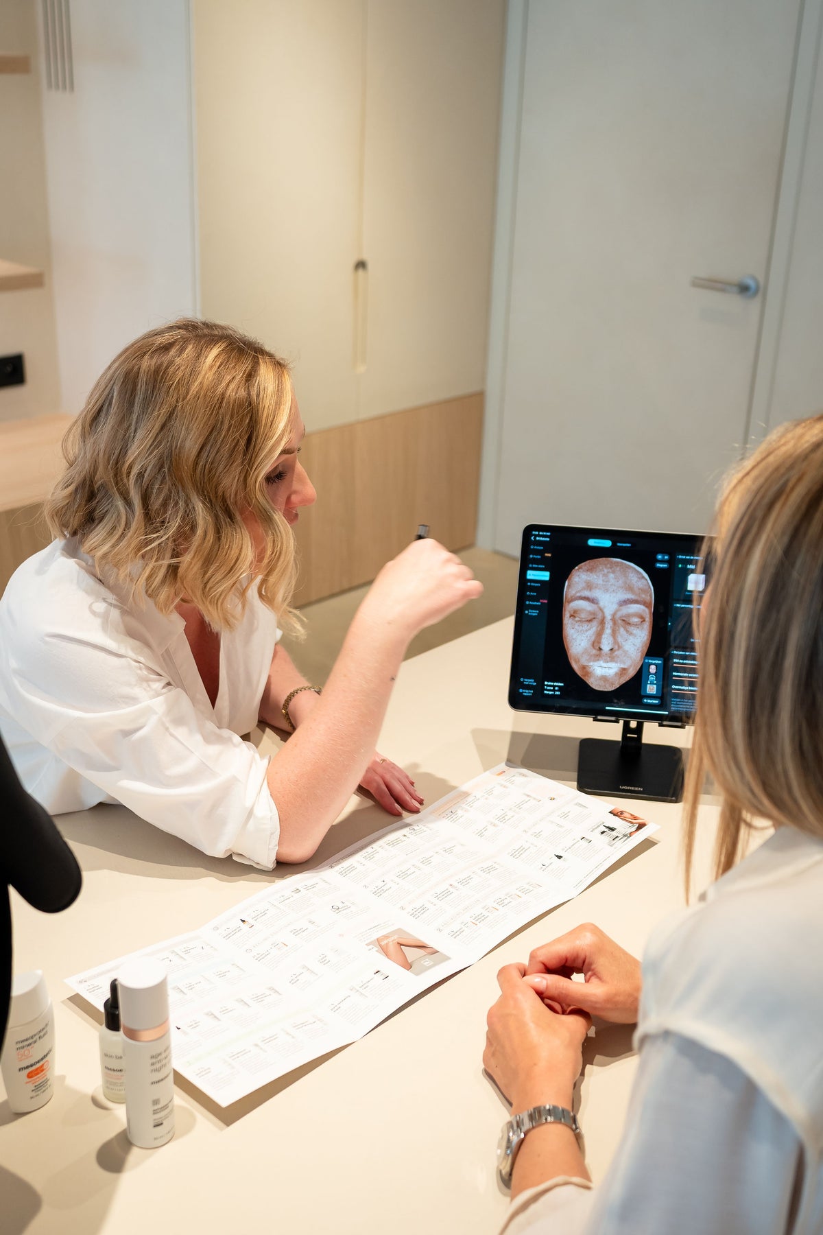 Babette bespreekt het huidbeeld van een klant op de tablet